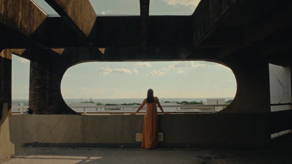 Mulher de costas olhando para a vista em uma janela circular no Genius Loci